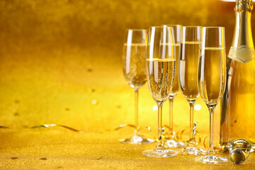 Champagne, bottle and streamers on golden background. Space for text