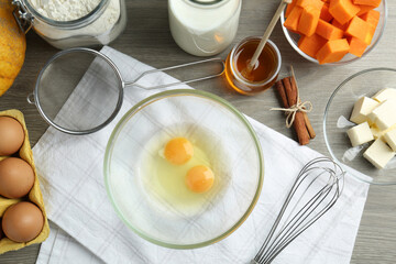Different ingredients for pumpkin pancakes on wooden table, flat lay