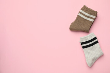 Different comfortable socks on light pink background, flat lay. Space for text