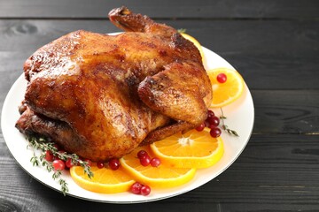 Delicious baked turkey, orange slices, cranberries and thyme on gray wooden table, closeup