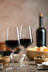 Red wine and delicious dinner served on wooden table