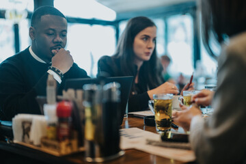 A group of diverse professionals having an engaging discussion and brainstorming session in a cafe, with visible focus and teamwork.