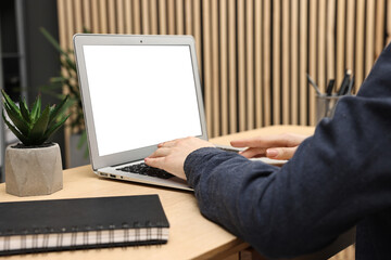 Woman working on computer at desk indoors, closeup