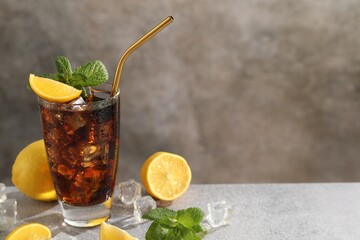 Fresh iced cola with mint and lemons on grey table, closeup. Space for text