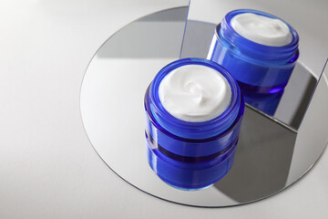Stylish presentation of facial cream on light background, closeup. Space for text