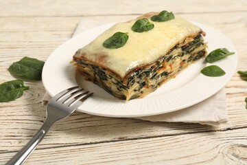 Piece of tasty spinach lasagna on wooden table, closeup
