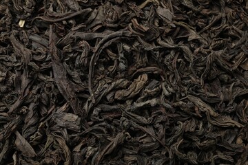 Pile of dry tea leaves as background, top view