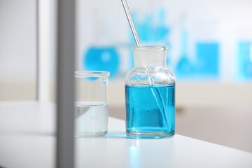 Laboratory glassware with liquid on shelf indoors
