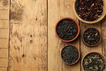 Different types of tea brew on wooden table, flat lay. Space for text