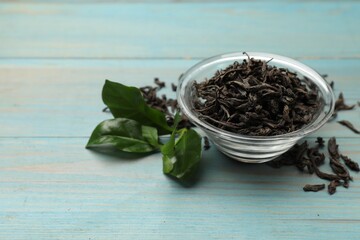 Dried and fresh tea leaves on blue wooden table, closeup