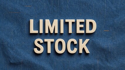 Close-up view of wooden letters spelling 'LIMITED STOCK' on textured blue background, suggesting scarcity and urgency