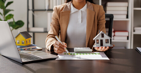 Female woman hand holding home model, investment small miniature white toy house. Mortgage property...