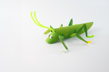 step in creative process, Completed Craft, The finished grasshopper, painted green with googly eyes...