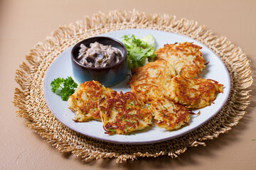 Hash browns with creamy mushrooms. Potato cakes or vegetable fritters, patties