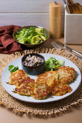 Hash browns with creamy mushrooms. Potato cakes or vegetable fritters, patties