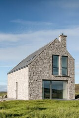 A contemporary stone house gracefully situated in a tranquil landscape, featuring expansive windows and a stylish sloping roof beneath a bright, clear sky