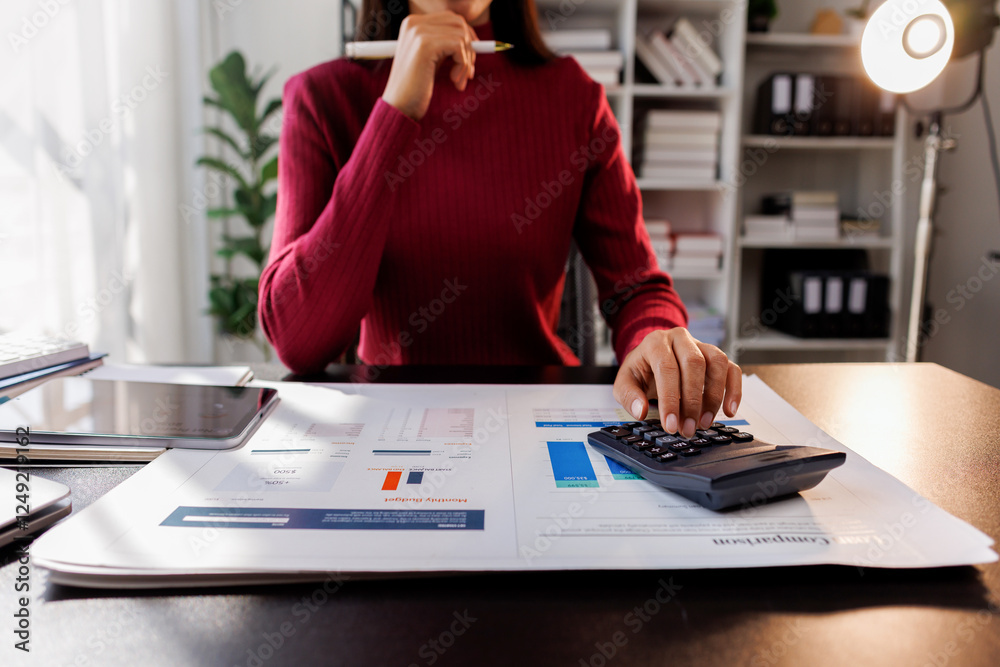 Wall mural Business financing accounting banking concept. Business woman hand doing finances and calculate on desk about cost at home office. Woman working on desk with using calculator, finance accounting.
