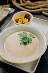 Creamy soup with croutons and fresh parsley, served with pita bread in elegant fine dining setting