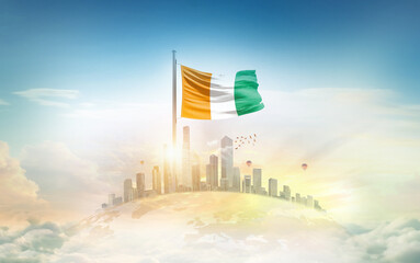 Ivory Coast flag wavering on blobe with modern building skyline. Flag waving on world map. Ivory Coast national flag for independence day.