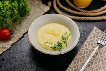 Creamy mashed potatoes garnished with fresh microgreens, in stylish and elegant food presentation
