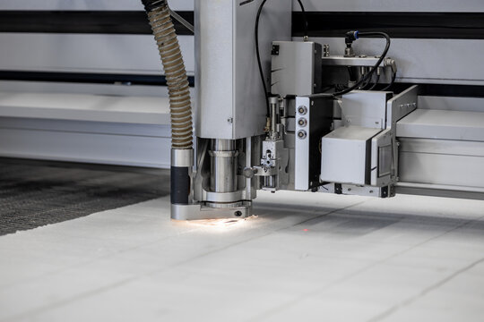 A high-tech CNC fabric cutting machine precisely cuts textile materials with automation. The advanced technology ensures accuracy and efficiency in industrial manufacturing and mass production
