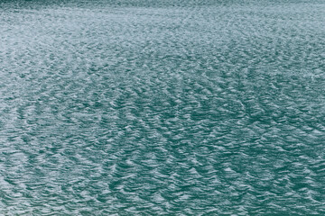 Detailed view of textured turquoise water with soft ripples and natural wave reflections forming an abstract and calm background at Lake Braies in Italy