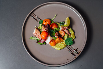 Flat lay Photo of seafood dish featuring octopus, fresh garnish, and artistic sauce drizzle served in a gourmet style