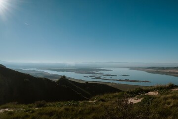 Tranquil lake and rolling hills under a clear sky