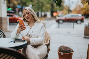 A woman sits at an outdoor cafe table while engaged with her smart phone. The scene captures leisure and modern connectivity in an urban environment.