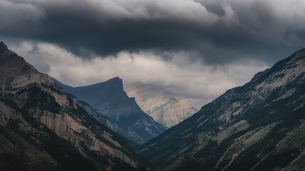 Fototapeta premium A breathtaking view of rugged mountains shrouded in dramatic clouds, showcasing nature's grandeur and the beauty of the wilderness.