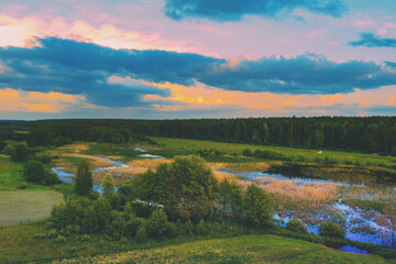 Obraz premium Aerial view of the countryside with dramatic evening sky during sunset. Rural landscape on a spring evening