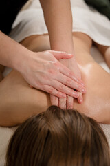 Therapist performing back massage with hands on a relaxed patient. Wellness and relaxation concept