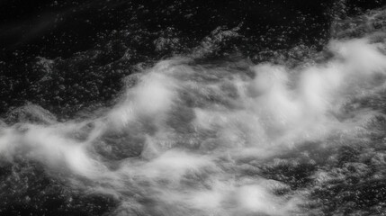 Fototapeta premium A close-up view of swirling water waves creating a dynamic pattern in black and white.