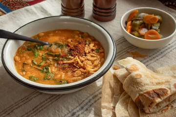 Vegan bean and spinach soup garnished with crispy onions and tamarind chutney