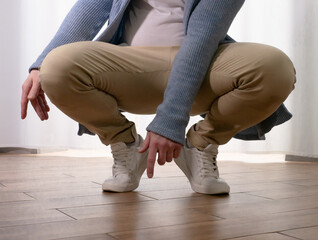 Young guy dancer in motion in a pose. A man performs a modern dance in casual clothes.