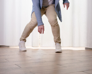 Young guy dancer in motion in a pose. A man performs a modern dance in casual clothes.