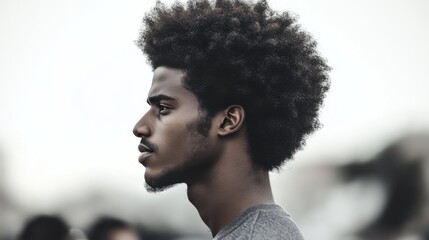 Obraz premium Man's profile, Afro hairstyle, city background, pensive mood, portrait