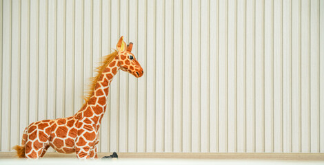 Adorable Giraffe Plush Toy Against Minimalist Vertical Striped Background.