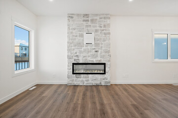 A large fireplace is the focal point of a large, empty living room