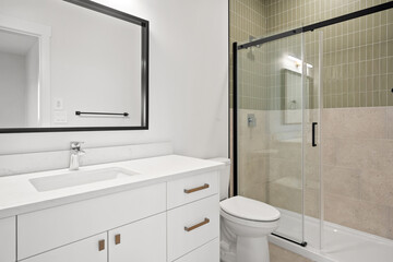 A bathroom with a white sink, toilet, and shower