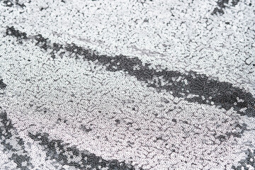 Abstract festive fabric texture with silver sequins.