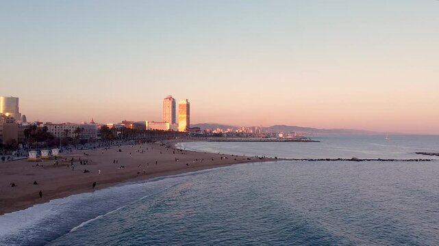Aerial drone view of Barceloneta beach at sunset. Dusk cityscape with mediterranean sea. Sunset skyline. Marina street and Port Olimpic