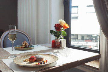 Luxurious sushi dishes are beautifully arranged on elegant plates, showcasing fresh ingredients. A table set for two features roses, creating a romantic ambiance suitable for a special occasion