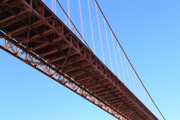Golden Gate Bridge Close-Up with Steel Framework Against a Clear Blue Sky