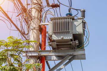 Electrical transformer on utility pole with wires and equipment in urban area