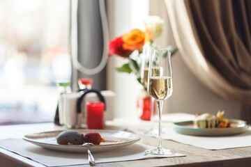 A beautifully set table adorned with elegant glassware and fresh flowers showcases exquisite sushi dishes. Perfect for a romantic Valentine's Day celebration with fine dining flair