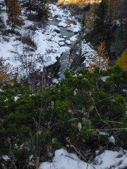 Snowy alpine valley near aosta, italy, revealing verdant landscape and golden hued trees during late autumn season Lillaz