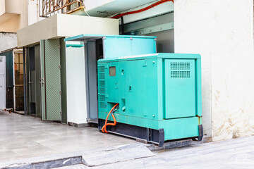 Large green industrial generator outside building