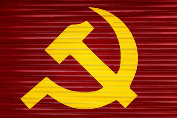 Yellow hammer and sickle on red metal shutter