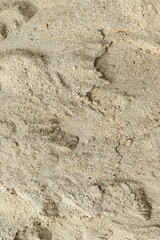 Close-up texture of natural sand surface with subtle shadows